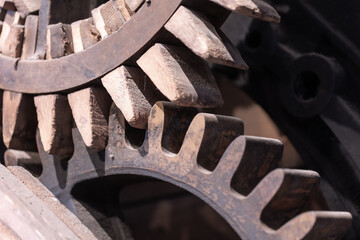 Rusty metal and wooden gears meshing together detail © jokuephotography