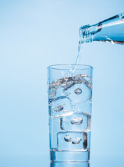 Crystal clear water being poured into a transparent glass, creating refreshing ripples and bubbles