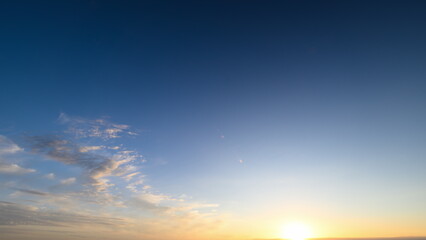 Morning light over wide tranquil landscape, Bright sunrise illuminating calm distant scenery, Radiant sunrise over spacious horizon with soft clouds and calming blue sky