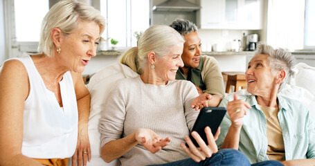 Fototapeta premium Phone, social media and senior women in living room for bonding, reunion and together in home. Smile, retirement and group of mature friends on sofa with online gossip, internet post or blog in house