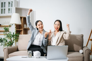 Happy businesswomen celebrating success at home office. Teamwork, financial growth, achievement, motivation and positive business result