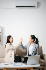 Happy Asian businesswomen celebrating success together at office. Teamwork, collaboration, business achievement, financial growth