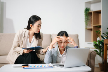 Stressed Asian businesswomen working together at home office. Financial problem, work stress, burnout, teamwork, budget planning