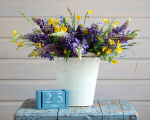 Wildflower bouquet in bucket with july 25 calendar date