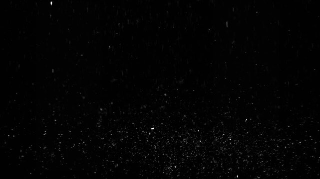 Raindrops falling on the ground on black background