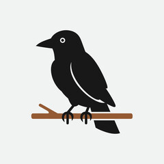 Obraz premium Black bird perched on a brown branch.