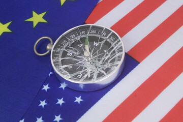 United States and European Union flags with broken compass. Problems of relationship between USA and EU.