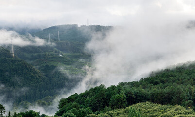 Fototapeta premium Electricity pylon on foggy mountain