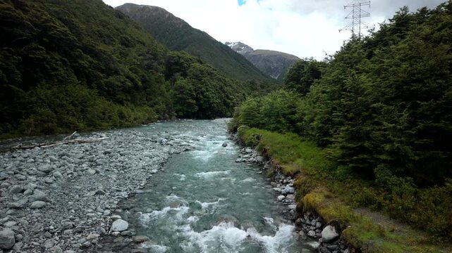 Mountain river flowing through lush valley with rocky banks