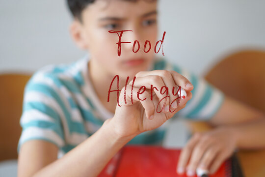 Food allergy. Teenager feeling unwell, writing on the screen with a red marker.