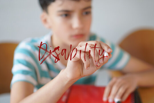 dis - ability. Teenage student writing the word disability and crossing out the prefix &ldquo;DIS&rdquo;