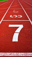 A red athletic track with white markings and lane numbers