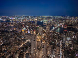 Fototapeta premium Aerial Night View of Lower Manhattan Skyline with Brooklyn Bridge and City Lights