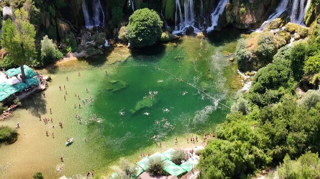 Close up drone footage of Kravica waterfalls focusing on powerful water cascades splashing over rock formations
