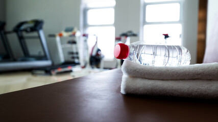Water and towels on the gym bench