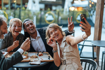 Business colleagues taking selfie while enjoying lunch break together