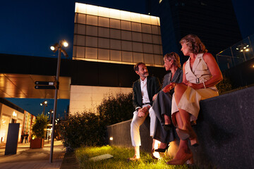 Businesspeople chatting during a break in the city at night