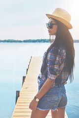 Thinking, calm and sunglasses with woman at lake pier for summer vacation, peace and tourism. Reflection, travel and adventure with female person outdoor for mindset, holiday and inspiration space