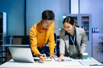 Fototapeta premium Asian business colleagues collaborating in modern office, discussing documents and strategy, teamwork, consulting and professional corporate workflow.