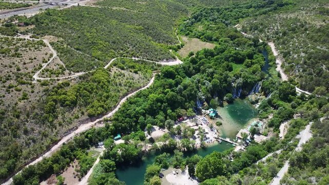 Drone view of Kravica waterfalls bathing park with cascades swimming areas and surrounding forest landscape