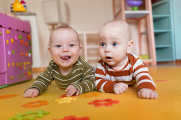 Fototapeta premium A spirited young boy sits in his high chair at kindergarten, proudly displaying his food-covered hands and face after a delightful meal. Joyful chaos!