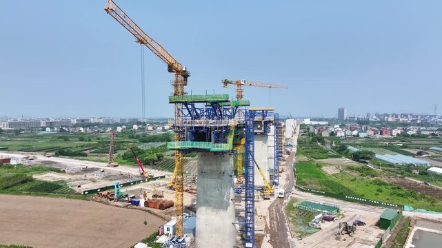Bridge construction in progress with towering crane and concrete piers under development