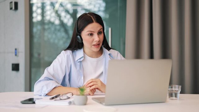 Focused professional conducts virtual business discussion. Engaged communication and clear gestures convey ideas effectively. Expresses commitment and dedication during important online meeting.