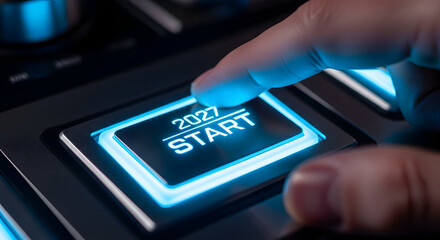 Close up of hand pressing a glowing blue futuristic start button for the year 2027