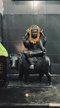 Lord Shani Dev riding a crow, adorned with marigold garlands, representing planetary Saturn and divine judgment in Hindu mythology.