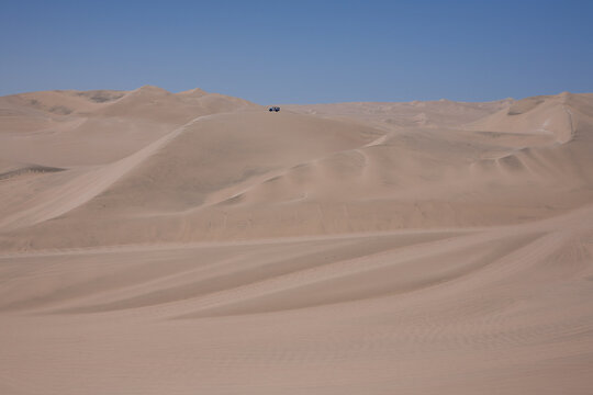 Sand dunes and dune buggy in Huacachina, Peru