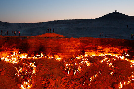 Tourists standing around the Darvaza Crater in Derweze, Turkmenistan