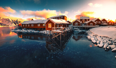 Lofoten Islands, Reine, Norway and Hamnoy fishing village with red rorbuer houses in winter sunset landscape