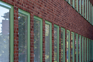 Urban modern architecture brick facade windows pattern repetition and texture with green accents creating clean abstract background for design