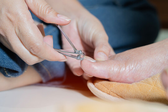Side view close-up of old elderly on cleanliness related to the body by cutting ingrown toenails