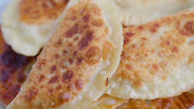 Crispy meat pastries, Home cooked cheburek pastries with meat and cheese filling, Traditional style fried chebureks showcasing crispy dough and savory interior flavors