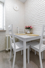 Cozy dining nook with white wooden table and floral decor