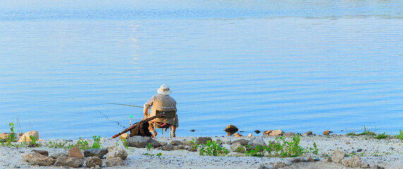 fisher man activity hobby by middle adult man back to camera sitting coast line near water panoramic outdoor