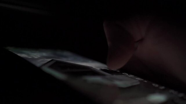 Man Scrolling Social Media on Smartphone at Night