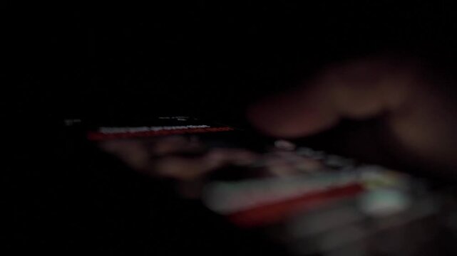 Man Scrolling Social Media on Smartphone at Night