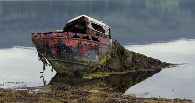 wide shot of A wrecked fishing boat on the shores of Loch Etive showing the left port side at Eilean Traighe