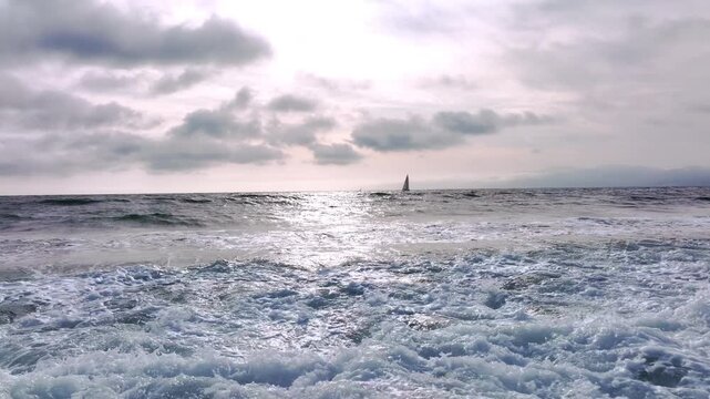 Ocean waves rolling to shore. Sea water moving forward. Ocean surf breaking on sand. Sea waves forming white foam. Ocean water rushing to beach. Sea surf in motion.