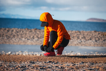 Female runner  running at winter high altitude lakeside, Tibet