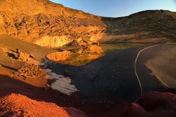 Lago Verde (Green lake) at sunset, surrounded by colorful landscape with volcanic rocks in El...