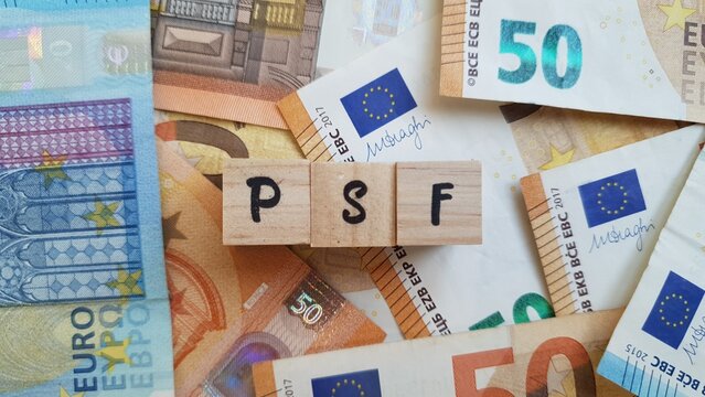 PSF acronym made of wooden letter cubes on pile of Euro banknotes. Plano de Poupan&ccedil;a Familiar (Family Savings Plan)