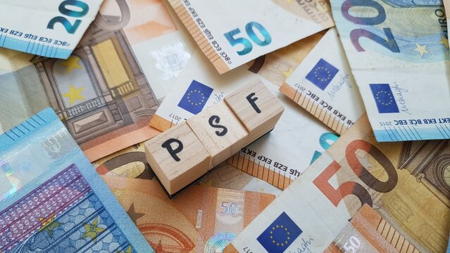 PSF acronym made of wooden letter cubes on pile of Euro banknotes. Plano de Poupan&ccedil;a Familiar (Family Savings Plan)