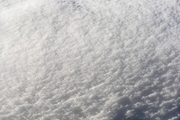 Obraz premium A high angle macro shot captures the detailed texture of fresh powdery white snow glistening under bright winter sunlight.