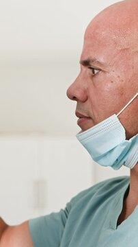Focused Male Doctor in Scrubs with Surgical Mask Pulled Down