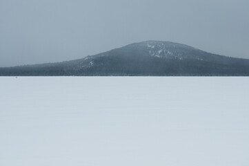 Winter view of snow-covered lake Zuratkul with mountain Lukash in the background, South Ural, Russia