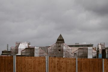 Renovation construction roof house scaffolding architecture stormy suburban restoration progress during home repair under overcast sky