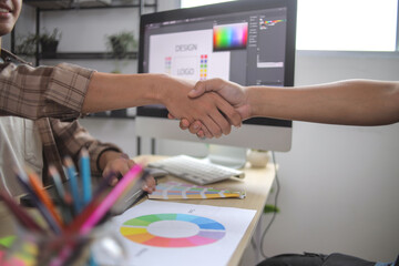 Two Young Designers Shake Hands After Collaborating on Successful Logo Project